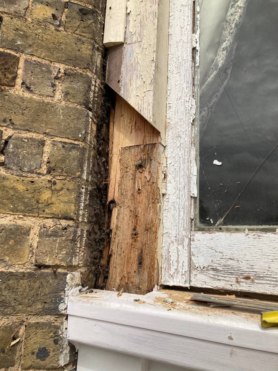 Rotten corner post on a bay window before repair