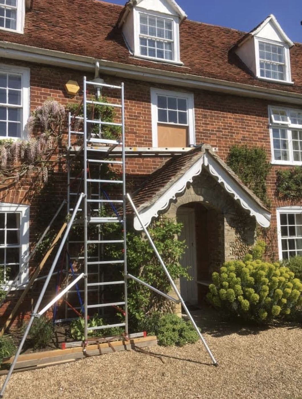 Scaffold tower set up for sash window repairs on a large brick period house
