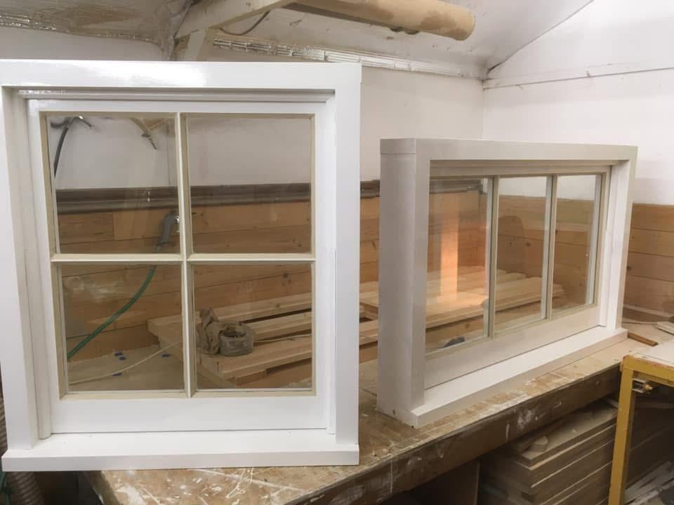 Two small timber windows painted in the workshop